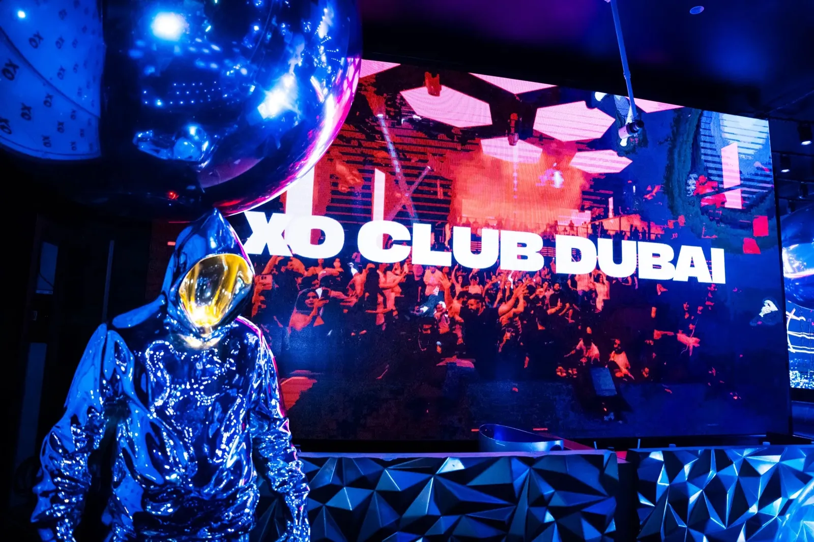 A costumed performer in front of the XO Club Dubai LED screen by the DJ booth