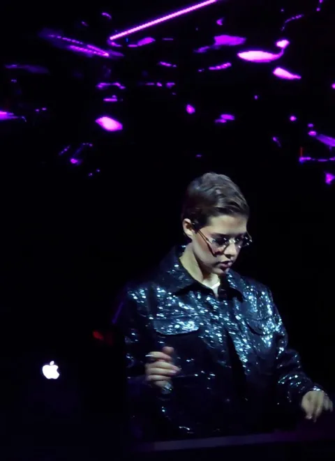 A DJ in a sequined jacket at the decks at XO Club Dubai