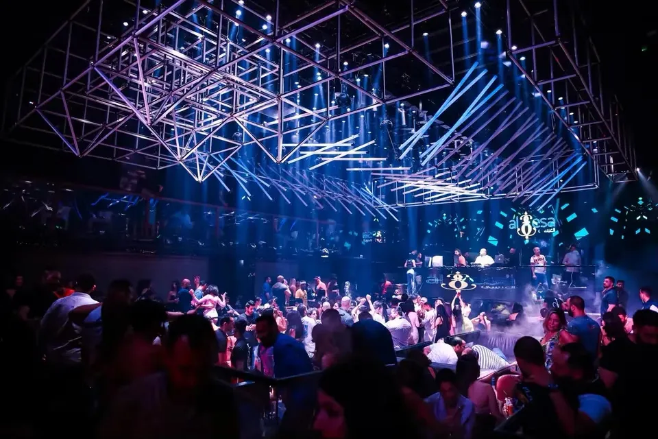 A full room under the geometric blue light rig at XO Club Dubai