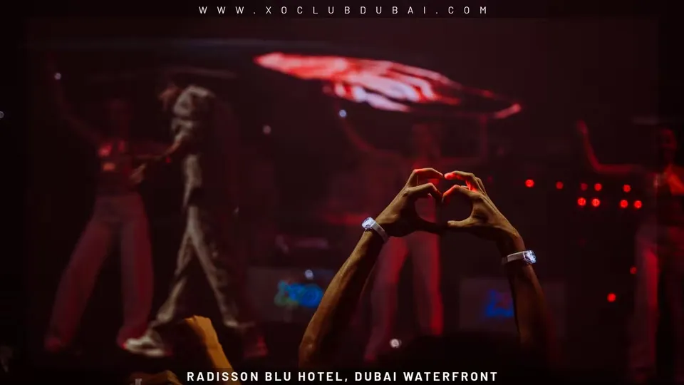 A guest making a heart with their hands toward a performer at XO Club Dubai