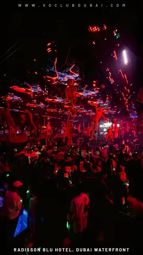 Aerial performers hanging above a red-lit crowd at XO Club Dubai