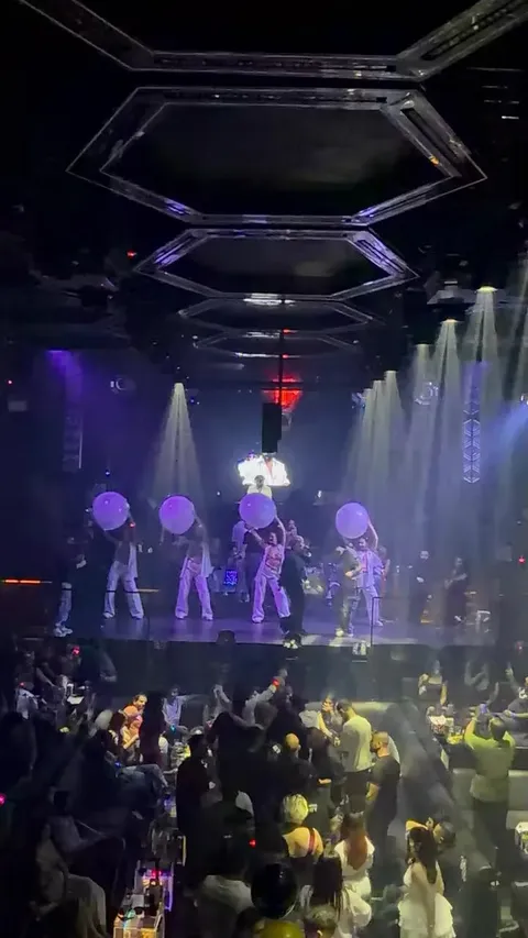 Dancers with glowing balloons on stage during a show at XO Club Dubai