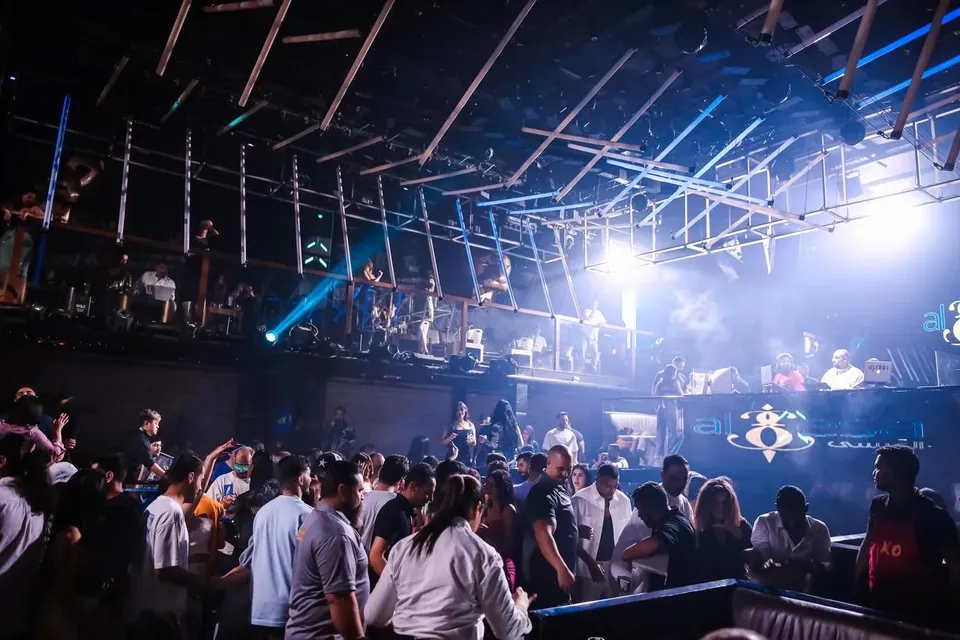 Guests dancing under blue spotlights on the main floor at XO Club Dubai