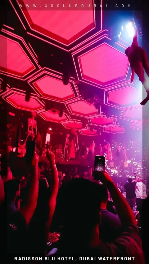 Guests filming under the pink hexagon ceiling at XO Club Dubai