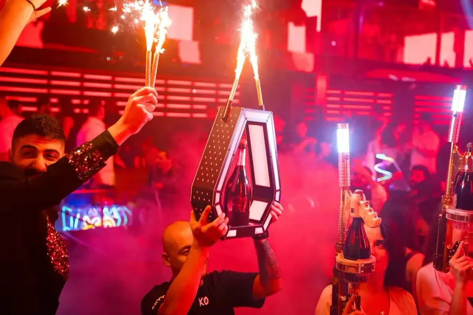 Staff carrying bottles with sparklers during bottle service at XO Club Dubai