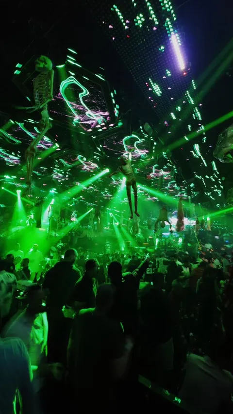 The crowd under green ceiling lights and screens at XO Club Dubai