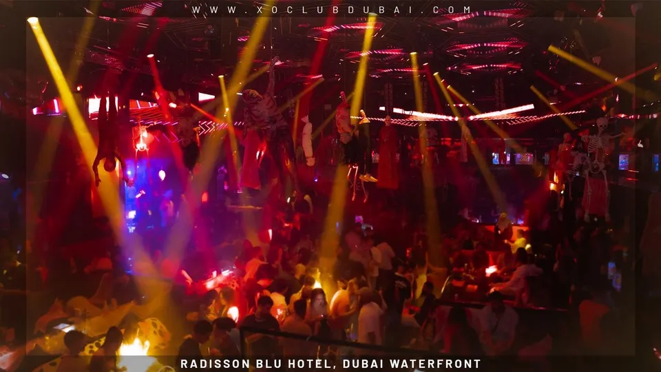 Yellow light beams cutting across the club floor at XO Club Dubai